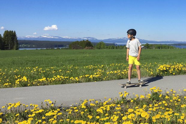 Barn på skatebord med utsikt över fjäll