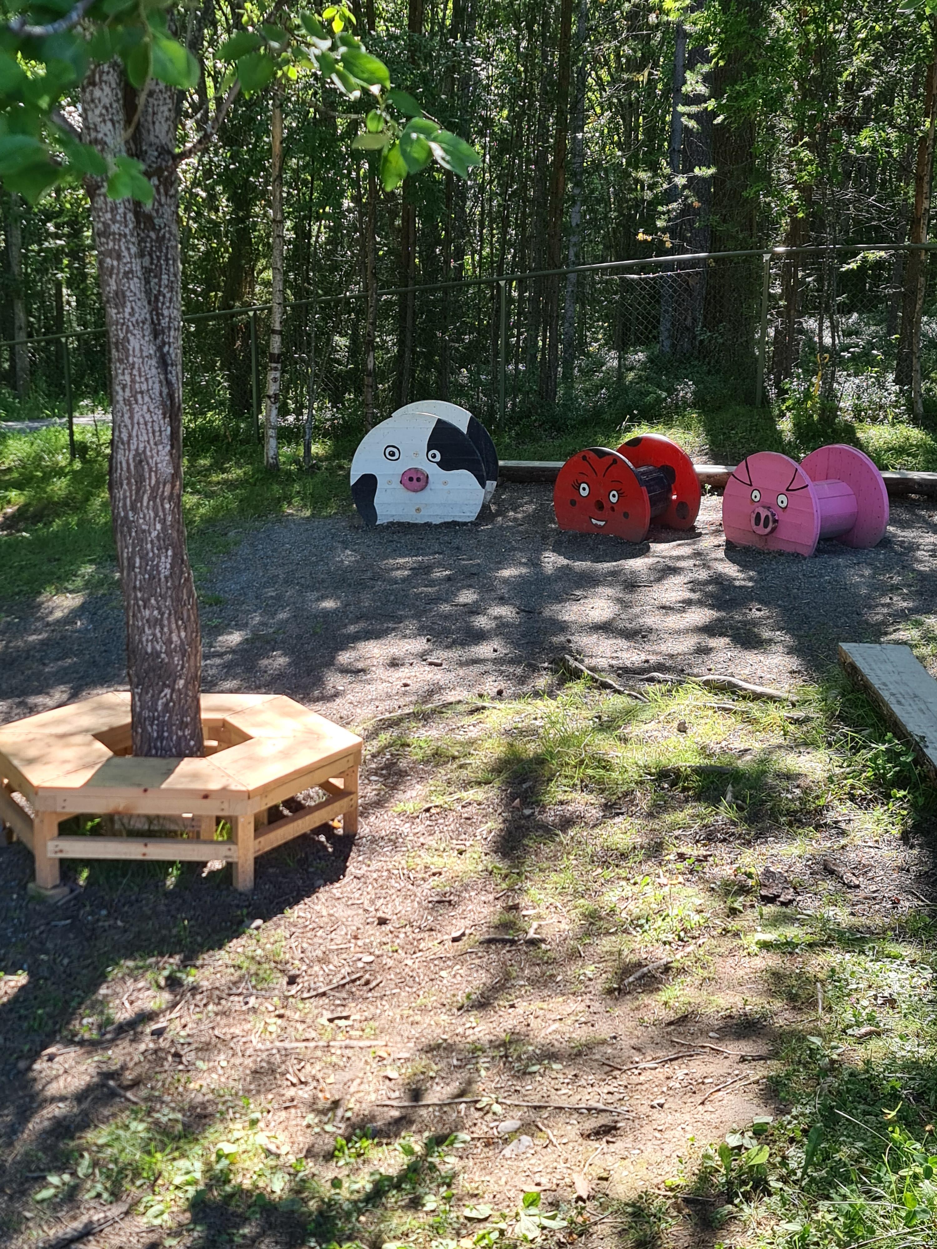 Sittplats runt träd samt träfigurer föreställande djur