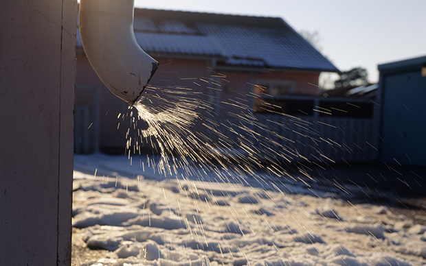 Vatten sprutar ut från ett stuprör