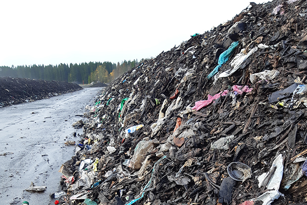 Brun matkompost och trädgårdsavfall och färgglada plastpåsar
