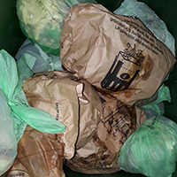 Fyllda matavfallspåsar både av papper och bioplast