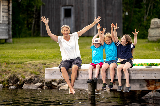 fyra personer som sitter på en brygga i landsbygdsmiljö