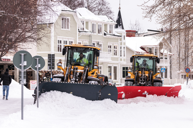 Två maskiner plogar undan snö från gata