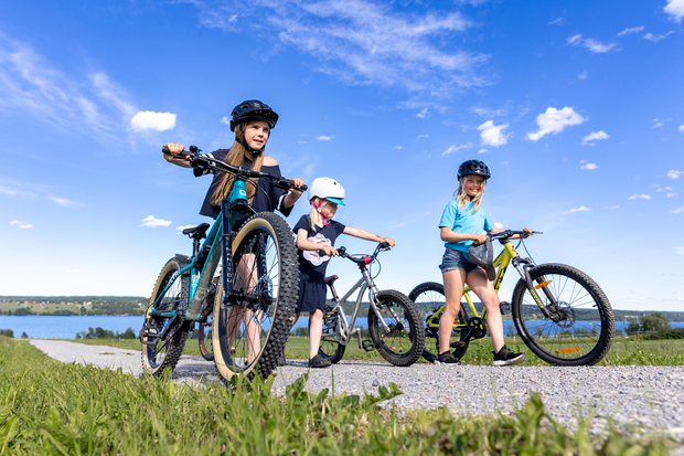 Barn ute med sina cyklar längs enslig väg