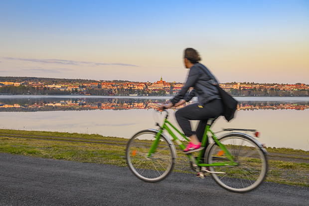 Cyklist vid vattnet med Östersund i bakgrunden.