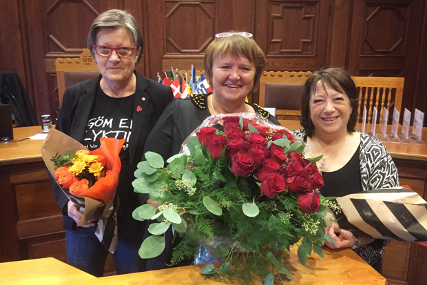 Tre personer med blombuketter