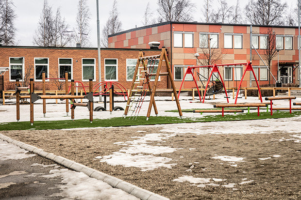 Översiktsbild på den upprustade skolgården, med själva skolbyggnaden med ny fasad i bakgrunden.