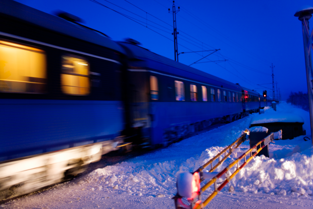 Bilden visar ett tåg i rörelse en snörik vinter.