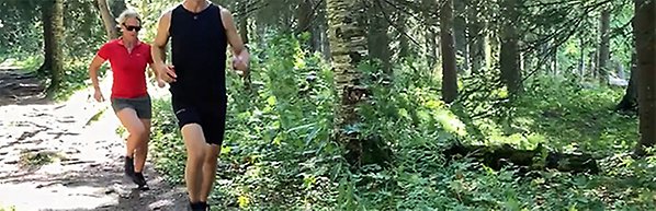 Bild på två löpare i skogen. 