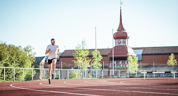 Bild på löpare på Hofvallens IP. I bakgrunden syns Jamtli. 