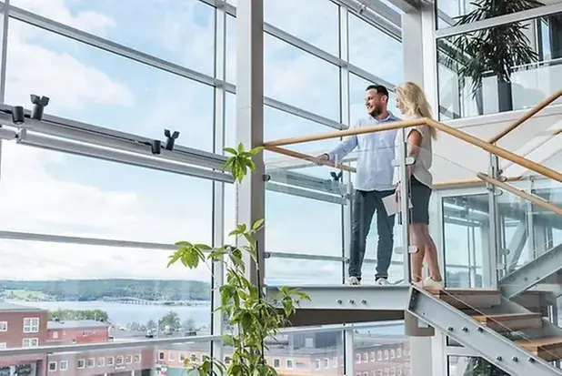Två personer står i trappa intill glasvägg