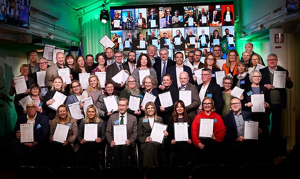 Uppradade personer med signerade klimatkontrakt (vita A4-papper) i händerna