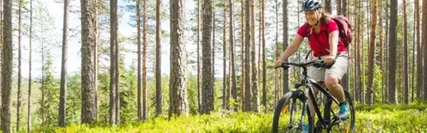 bild på en kvinna som cyklar på en naturstig