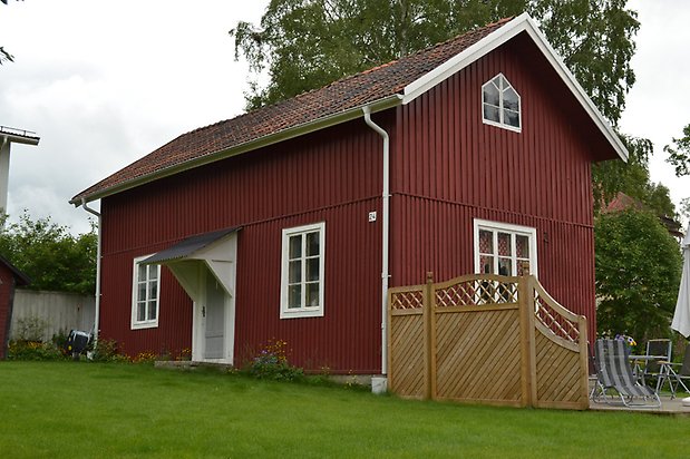 Majsen 1, Hus med röd, stående träpanel och vita fönster med spröjs.