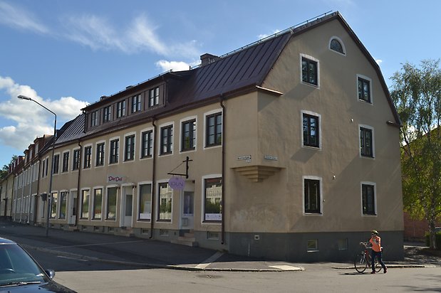 Mörten 1, Flerbostadshus i tre våningar i beige puts med svarta fönster och svart plåttak.