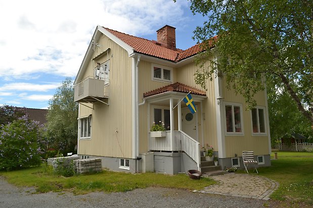 Hasseln 6, Villa i ljusgul träpanel, vita fönster och rött tegeltak.