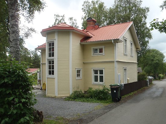 Klövern 4, Villa i ljusgul, liggande träpanel. Vita fönster och spröjs, rött tegeltak och en sexkantig utbyggnad.