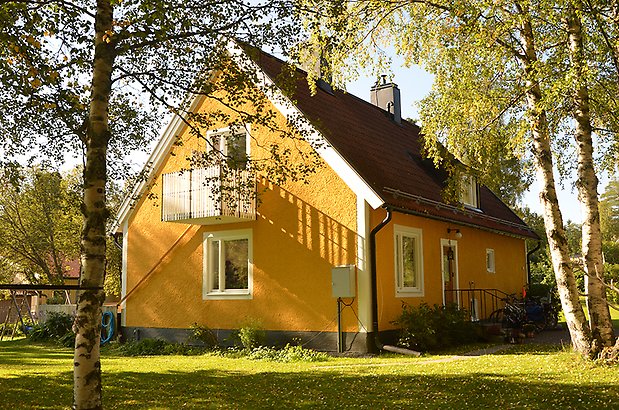 Mariedal 20. Villa i gul puta med vita detaljer och vita fönster med balkong och takkupa.