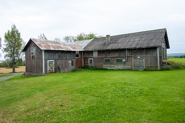 Boda 3:1. Ladugård byggd i vinkel, i grånad panel.