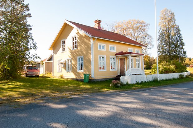 Fjäl 2:11. Villa i gul liggande panel med fönster med vita spröjs.