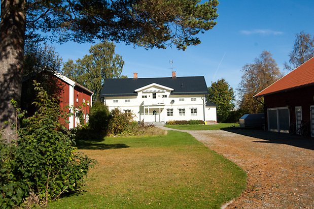 Fjäl 3:43. Stort vitt hus i två våningar med vita spröjs.