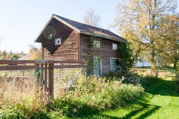 Fjäl 4:34. Timrad byggnad med grön port och dubbelport.