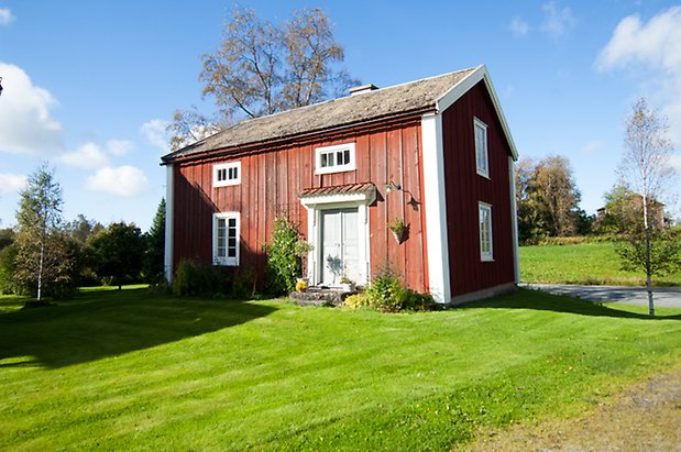 Husås 2:14. Hus i röd panel med vita dubbeldörrar med vita spröjs.