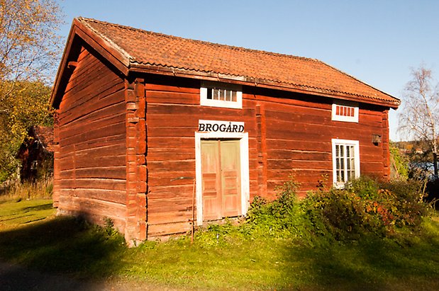 Hölje 1:21. Timrad, rödmålad byggnad med grön dubbeldörr och fönster med vita spröjs.