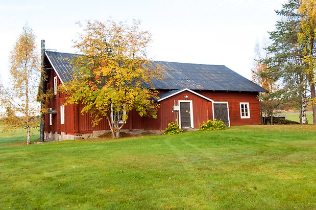 Hölje 3:4. Byggnad i två våningar i röd panel med svart dubbelport och dörr och fönster med spröjs.