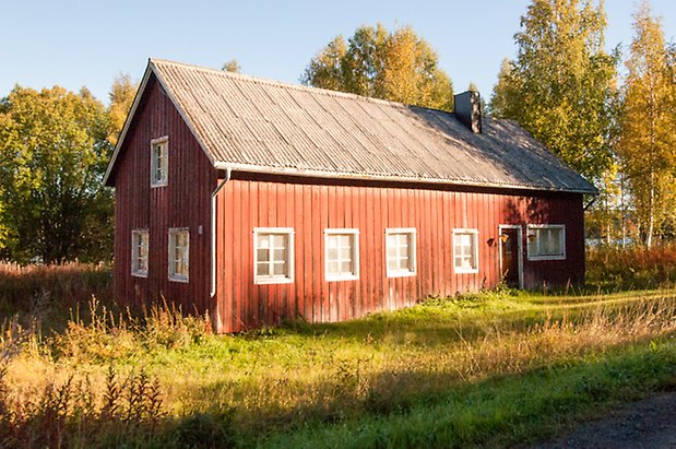 Hölje 4:7. Hus i två våningar i röd panel med brun dörr och fönster med vita spröjs.