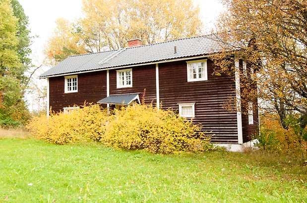 Korsta 2:19. Hus i två våningar brun liggande panel, fönster med vita spröjs.