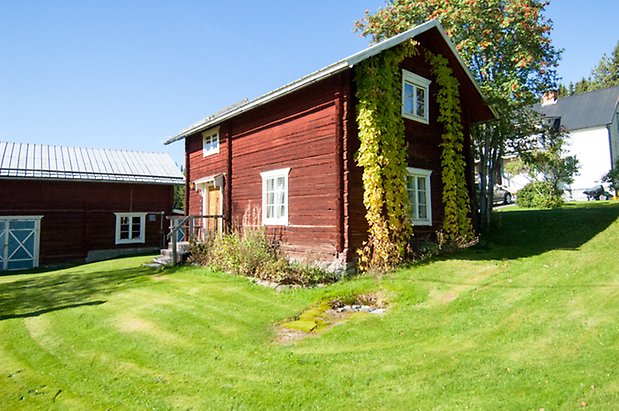 Lits-Backen 1:23. Röd, timrad byggnad i två våningar med gul dörr och fönster med vita spröjs.