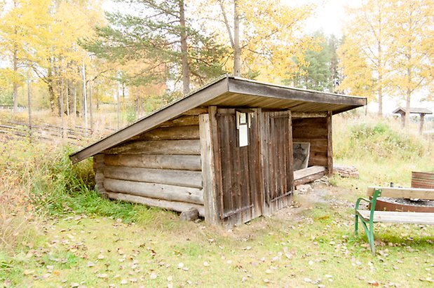 Lits Prästbord 1:18. Grått, timrat vindskydd.