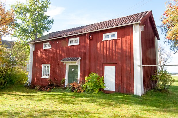 Palleråsen 1:8. Hus i två våningar i röd panel, gröna dubbeldörrar, fönster med vita spröjs.