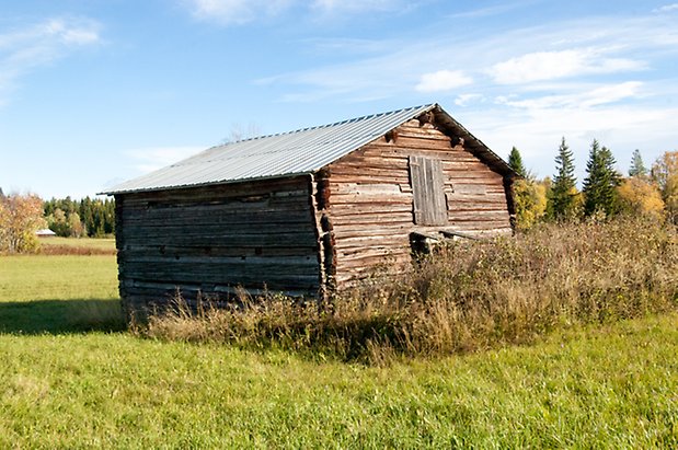 Palleråsen 1:8. Grå byggnad i timmer.