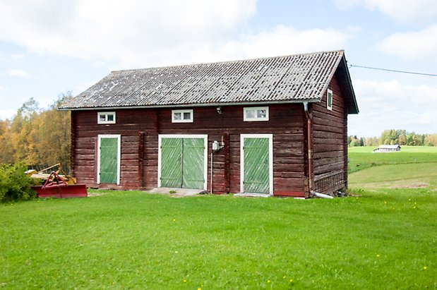 Ringsta 3:26. Timrad, brun byggnad med två gröna portar och en dubbelport. 