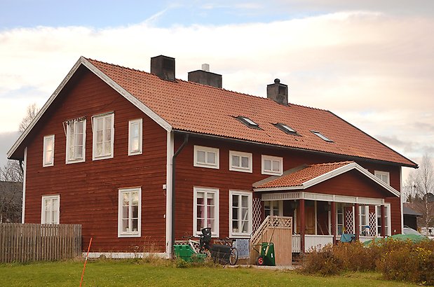 Stallet 11. Gammalt rött hus med vita fönster med spröjs.