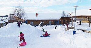 Barn som leker på förskolans gård i vinter