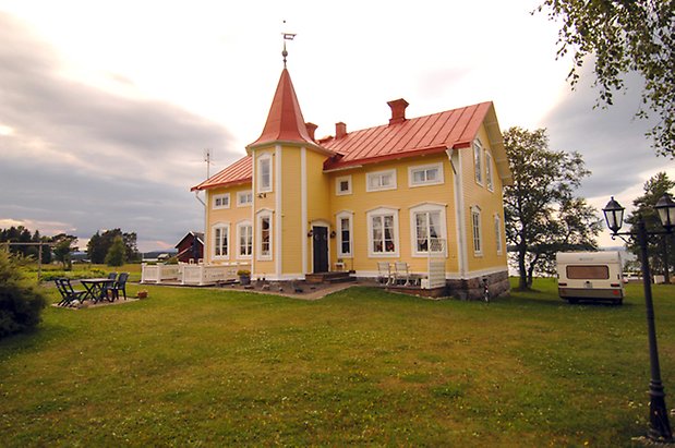 Digernäs 1:4. Hus i två våningar i gul, liggande panel, ett torn på mitten av huset, fönster med vita spröjs.