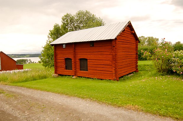 Hara 8:2. Timrad, röd byggnad med två svarta luckor.