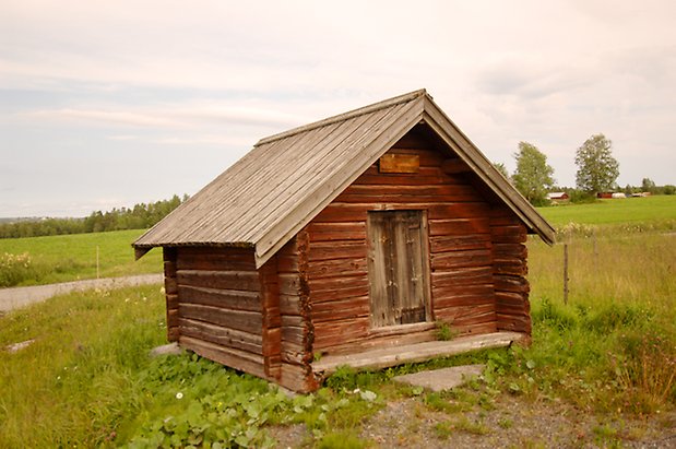 Hegled 1:11. Liten, brun timrad byggnad med lucka.