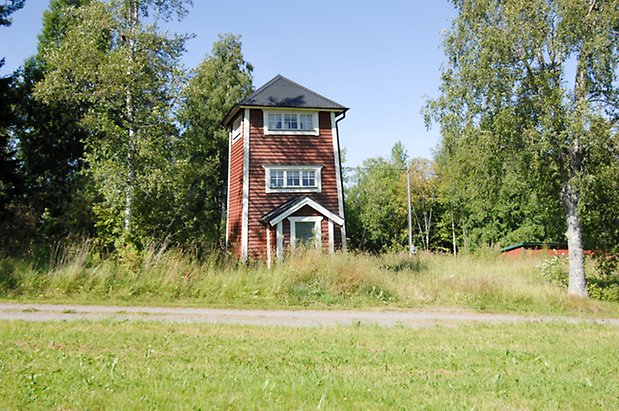 Slandrom 4:1. Torn i röd, liggande panel med grön dörr, fönster med vita spröjs.