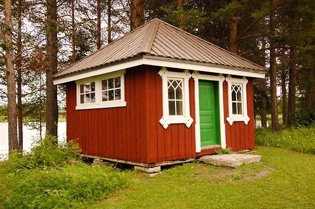 Sunne Prästbord 1:2. Liten byggnad i röd panel, med grön dörr och fönster med vita spröjs.