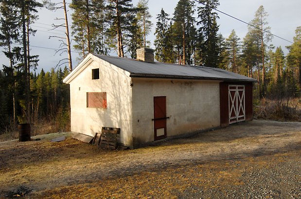 Åsan 1:2. Ladugård i vit puts och röd panel, röd dubbelport med vita kryss och röd port.