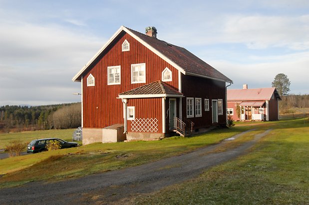 Åsan 1:9. Hus i röd panel med källare med fönster med vita spröjs, två dörrar.