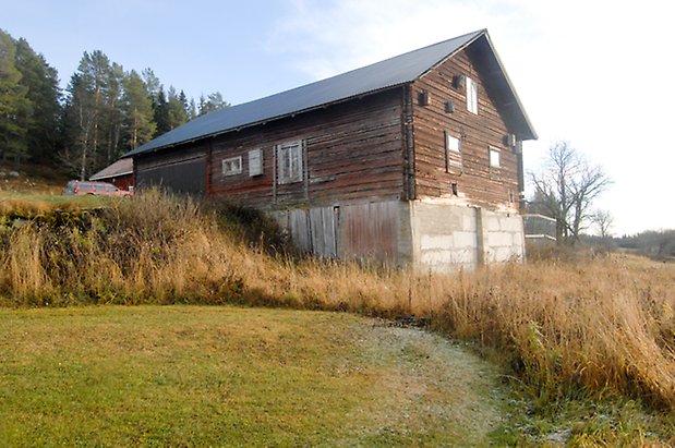 Åsan 1:9. Ladugård i tre våningar, nedervåningen i betong och övre våningar i brun, liggande panel. 