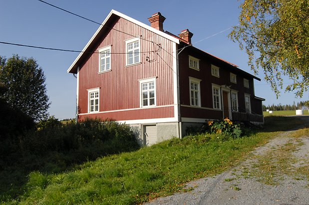 Jälsta 1:2. Hus i två våningar i röd panel, med källare i betong, fönster med vita spröjs.