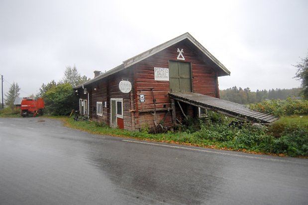 Västanede 2:1. Ladugård i rött timmer med grön dubbelport och två portar, fönster med vita spröjs.