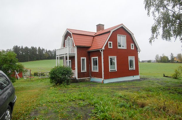 Västanede 3:5. Villa i röd, liggande panel, förstukvist med balkong ovanför.