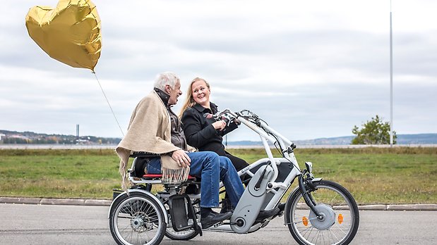 En äldre man åker tillsammans med en ung tjej på en specialbyggd cykel
